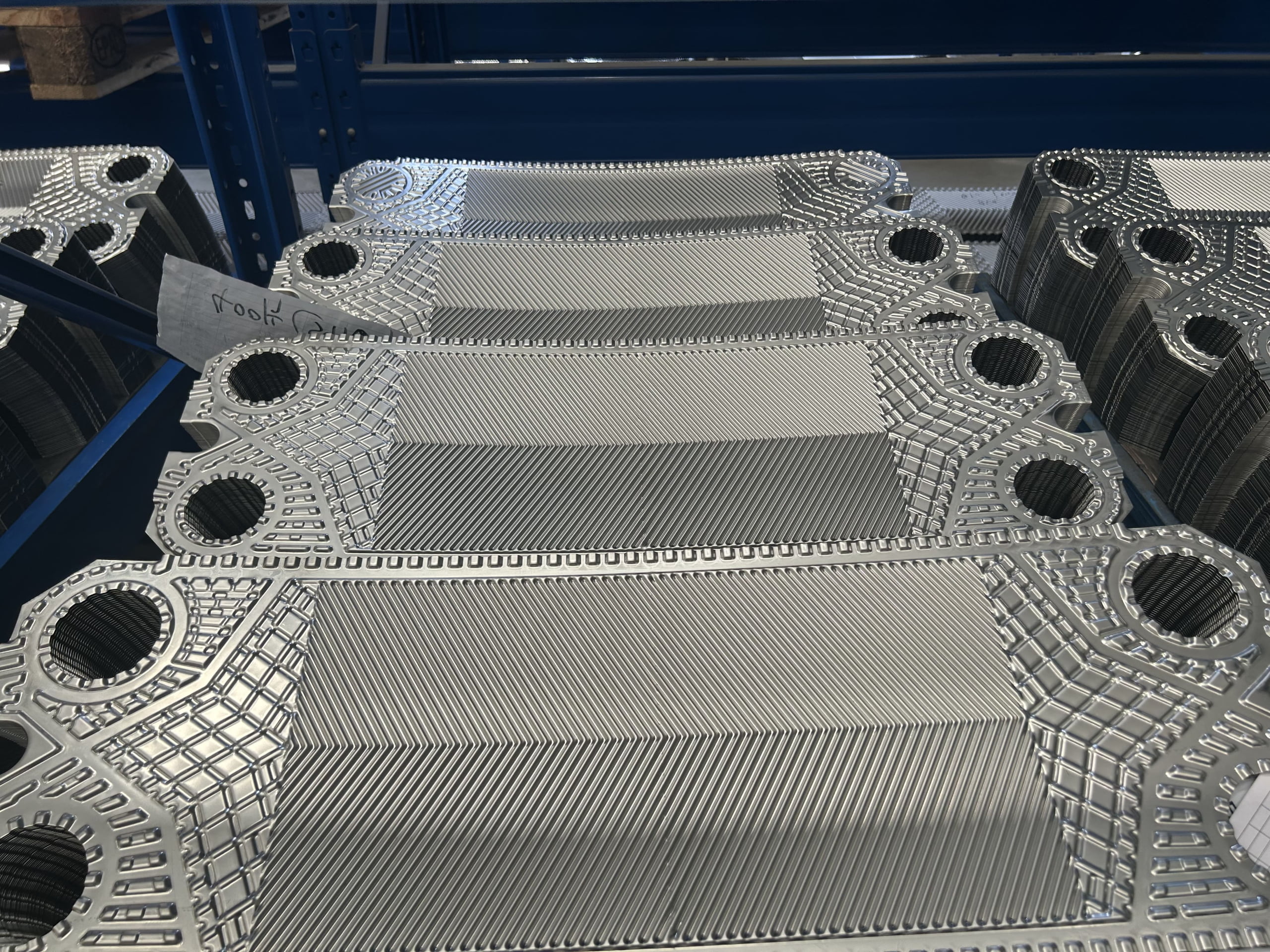 A technician performing spectral material testing on a stainless steel plate